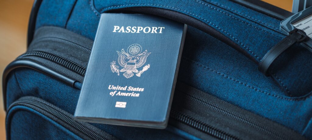 Picture of a american passport on a blue travel bag.